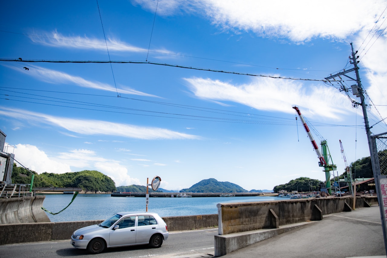 室尾の瀬戸内海沿いを走る車と造船場の写真
